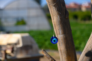 Colorful talisman hanging from a wooden post in a vibrant green field under bright blue skies