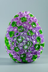 Quilled Easter Egg. Intricate paper art decoration with green and purple coils.