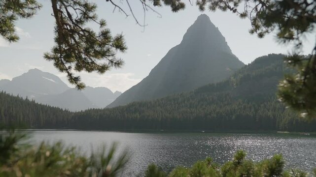 Serene lake view with pine trees and mountain in Montana during calm daylight