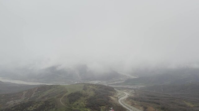 Overcast aerial view of Muganli-Ismayilli-Gabala highway winding past Aghsuchay River. Gabala, Azerbaijan