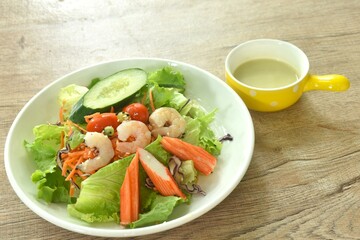 boiled shrimp and crab stick with vegetable seafood salad on plate dressing cream sauce