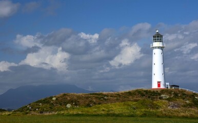 the iconic cape egmont lighthouse on the bluffs off of state highway 45 on a sunny summer day  near pungarehu on the west coast of the north island of new zealand