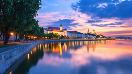 Fototapeta premium Scenic Sunset View Over City River with Colorful Sky Reflections