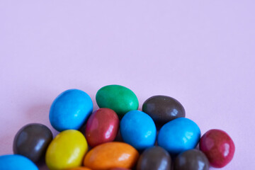 Colorful candies on pastel pink background. Top view.