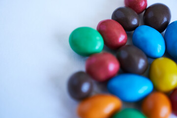 Colorful chocolate candies on white background. Selective focus.