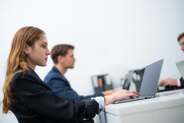 Fototapeta premium Professionals engaged in focused work at a modern office during daytime hours