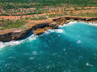 Ocean Waves Crashing Against Rocky Cliffs Along a Coastal Beach, Caribbean sea shoreline