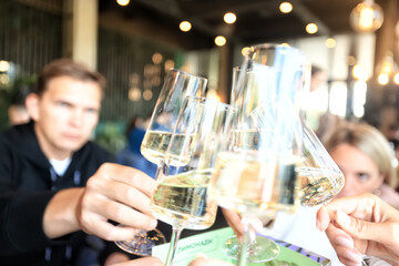 Friends with glasses of wine clink glasses holiday, a group of people abstract blurred background