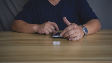 A man is using his smartphone on a wooden desk. Idea for modern living and comunication.