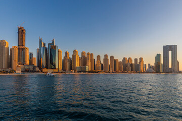 Modern Dubai Marina skyline at golden hour, Stunning waterfront view of Dubai Marina skyline with high-rise buildings reflecting.
