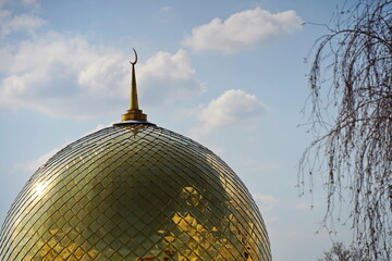 The golden dome of the mosque with a crescent moon. The minaret. Urban architecture. © Vladimir