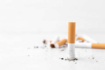 Cigarette butts on light background, selective focus. Space for text