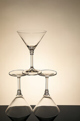 Three empty clean glasses on black table against beige background