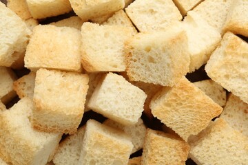 Tasty crispy croutons as background, top view