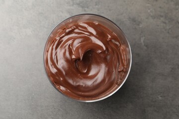 Tasty chocolate pudding on grey table, top view
