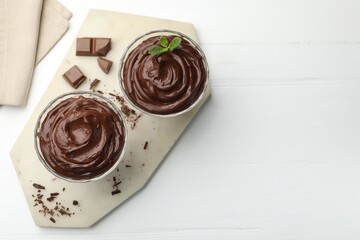 Delicious chocolate pudding on white wooden table, flat lay. Space for text