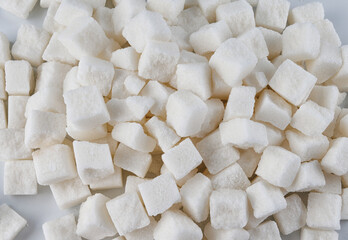 Background of pieces of crushed white sugar. White sugar.