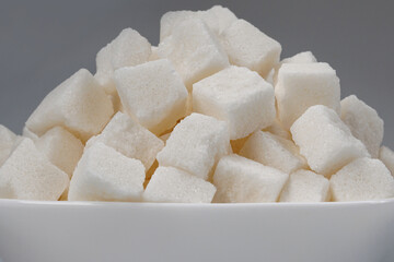 White sugar in a white plate. Sugar in pieces.