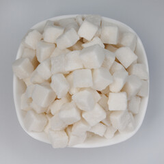 White sugar in a white plate. Sugar in pieces.