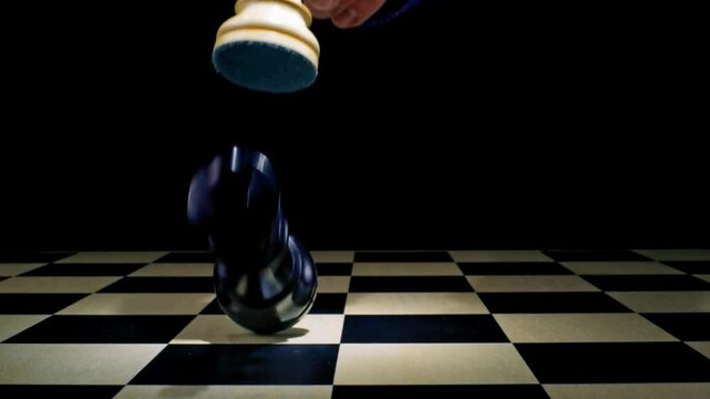SLO MO LD Male hand picking up a white queen and knocking over the black king on the chess board