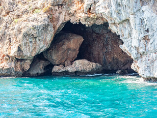 Grotto and coastal cliffs. The blue Mediterranean Sea. Antalya, Turkey