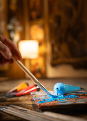 Artist s hands with brushes mixing colors