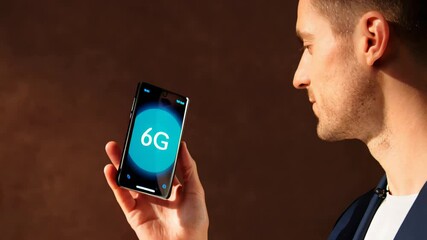 Businessman holding smartphone displaying 6G network on screen - Powered by Adobe