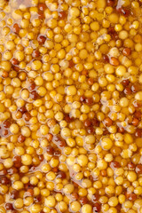 French Dijon mustard in a metal spoon, top view on mustard grains background. Gastronomy concept,...