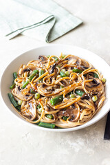 Udon noodles in teriyaki sauce with mushrooms, beans and peas. Asian cuisine. Vegetarian food.
