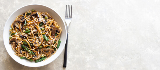 Udon noodles in teriyaki sauce with mushrooms, beans and peas. Asian cuisine. Vegetarian food.