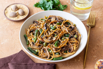 Udon noodles in teriyaki sauce with mushrooms, beans and peas. Asian cuisine. Vegetarian food.