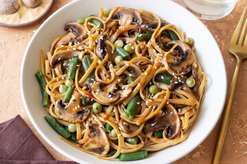 Udon noodles in teriyaki sauce with mushrooms, beans and peas. Asian cuisine. Vegetarian food.