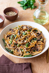 Udon noodles in teriyaki sauce with mushrooms, beans and peas. Asian cuisine. Vegetarian food.