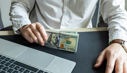man holds hundred dollar bills. dollar investment and cost of living	