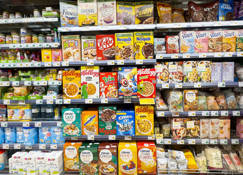 Variety of breakfast cereals on supermarket shelves with colorful packaging