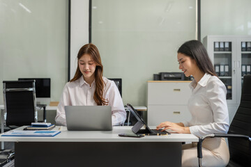 Fototapeta premium Business team analyzing documents, graphs, and data with a laptop, tablet, and smartphone. Collaboration, strategy, and success in a modern office.