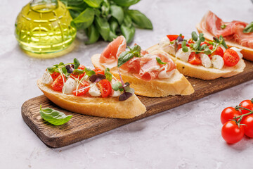 Tasty antipasto toasts featuring classic caprese with mozzarella and tomatoes, and savory prosciutto with herbs