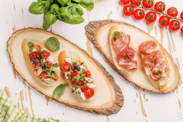 Tasty antipasto toasts featuring classic caprese with mozzarella and tomatoes, and savory prosciutto with herbs