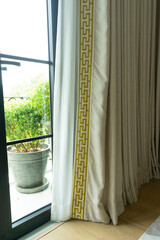 Close up of a curtain with gold trimmings in a luxury mansion.