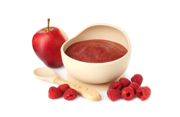 Baby food. Tasty puree in bowl, spoon, apple and raspberries isolated on white