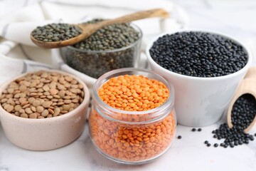 Different types of lentils on white table, closeup