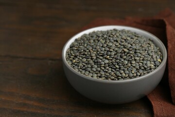 Raw green lentils on wooden table, closeup. Space for text