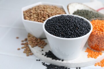 Different types of lentils on white table, closeup