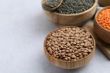 Different types of lentils on light table, closeup. Space for text