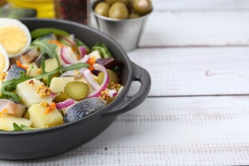 Delicious salad with herring, egg and vegetables on white wooden table, closeup. Space for text