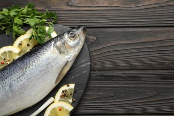 Salted herring and spices on wooden table, top view. Space for text