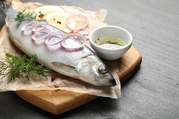 Tasty herring with spices on black table, closeup