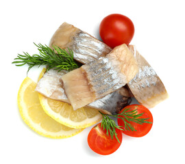 Pieces of delicious herring with lemon slices, tomatoes and dill isolated on white, top view