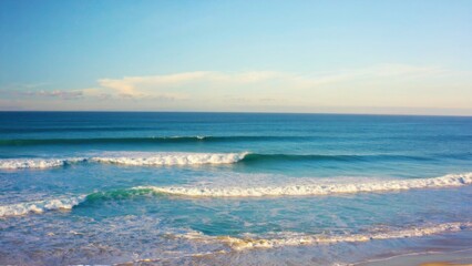 Obraz premium Waterfront scene with white caps on the waves and a clear blue sky.
