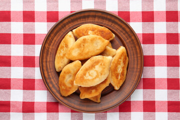 Delicious fried pyrizhky (stuffed pies) on table, top view